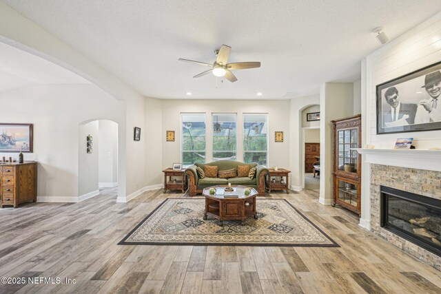 1009 Welaka Way, Saint Augustine, FL 32092 - living room featuring arched walkways, a ceiling fan, wood finished floors, a glass covered fireplace, and recessed lighting