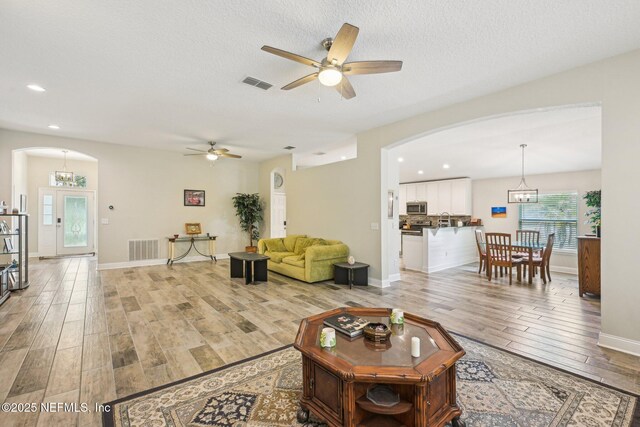 1009 Welaka Way, Saint Augustine, FL 32092 - living room with arched walkways, light wood-style flooring, ceiling fan, recessed lighting, and baseboards