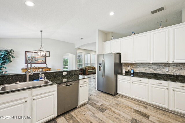 1009 Welaka Way, Saint Augustine, FL 32092 - kitchen featuring appliances with stainless steel finishes, a sink, arched walkways, vaulted ceiling, and decorative backsplash