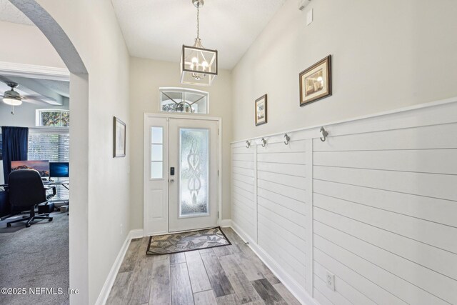1009 Welaka Way, Saint Augustine, FL 32092 - entrance foyer with arched walkways, wood finished floors, a chandelier, and baseboards