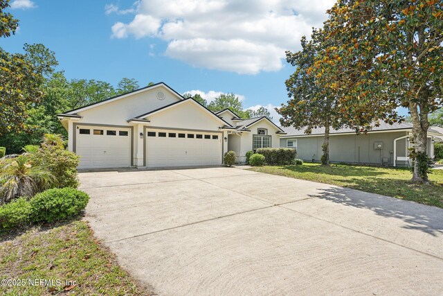 1009 Welaka Way, Saint Augustine, FL 32092 - ranch-style house featuring concrete driveway, an attached garage, stucco siding, and a front lawn