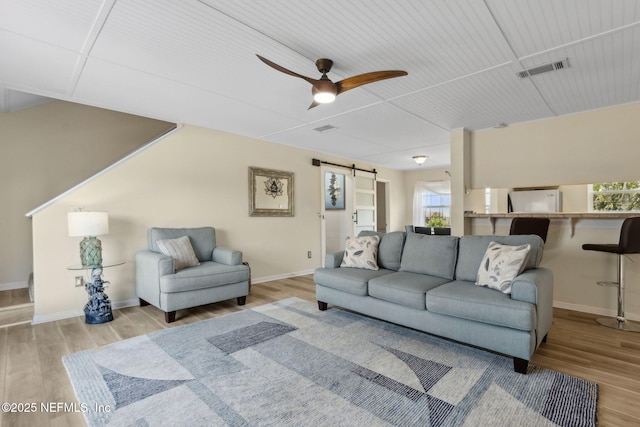 925 Tarpon Ave Unit 16, Fernandina Beach, FL 32034 - living room featuring a barn door, wood finished floors, baseboards, and ceiling fan