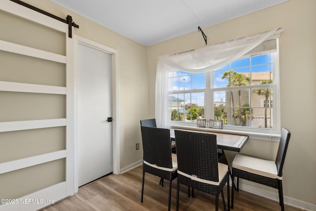 925 Tarpon Ave Unit 16, Fernandina Beach, FL 32034 - dining space featuring wood finished floors, baseboards, and a barn door