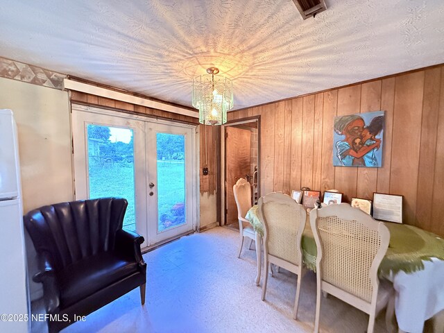 4507 Harbor View Dr, Jacksonville, FL 32208 - dining area featuring a chandelier, wooden walls, and french doors