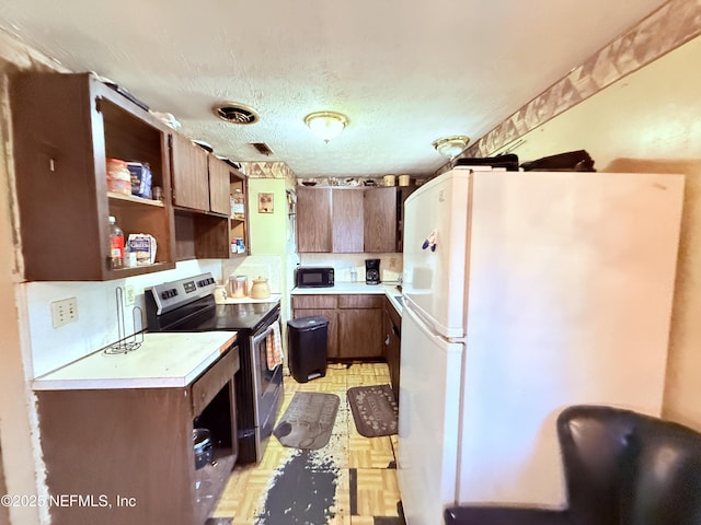 4507 Harbor View Dr, Jacksonville, FL 32208 - kitchen featuring freestanding refrigerator, stainless steel range with electric cooktop, open shelves, light countertops, and black microwave