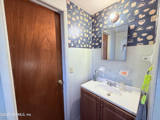 4507 Harbor View Dr, Jacksonville, FL 32208 - bathroom featuring wallpapered walls, vanity, and a textured ceiling