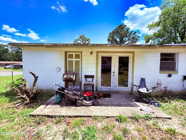 4507 Harbor View Dr, Jacksonville, FL 32208 - rear view of house featuring french doors, fence, a patio, and concrete block siding