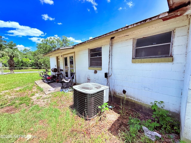 4507 Harbor View Dr, Jacksonville, FL 32208 - view of property exterior featuring concrete block siding, central air condition unit, a yard, french doors, and a patio area