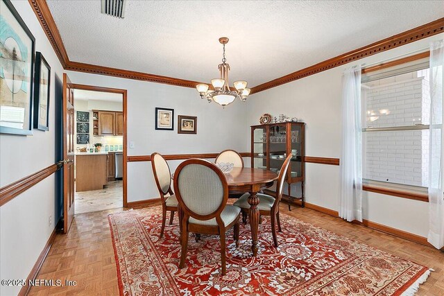 73 Waterbridge Pl, Ponte Vedra Beach, FL 32082 - dining space with baseboards, a textured ceiling, a chandelier, and ornamental molding