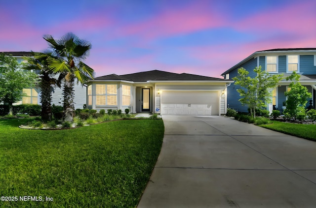 view of front of home featuring an attached garage, concrete driveway, and a front lawn