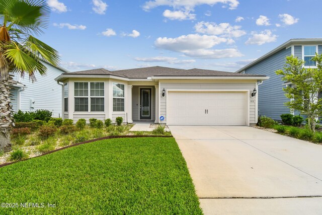 view of front of house with a garage, concrete driveway, and a front lawn