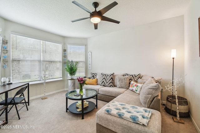 carpeted living room with a ceiling fan and baseboards
