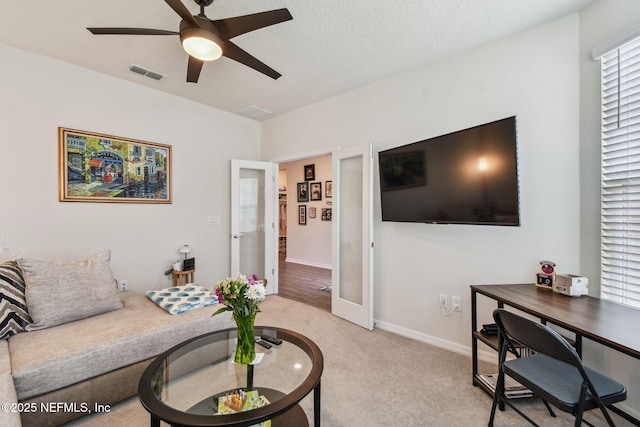 living room with an office area, a ceiling fan, light carpet, and baseboards