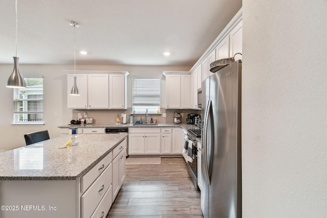 kitchen featuring stainless steel appliances, plenty of natural light, white cabinetry, and recessed lighting