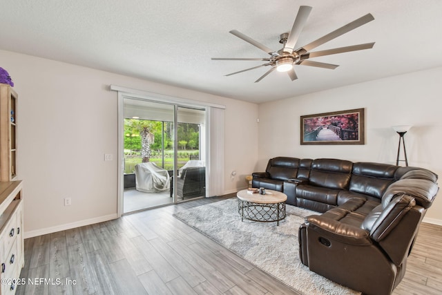 living room with a ceiling fan, wood finished floors, and baseboards