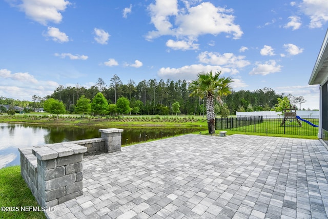 view of patio featuring a playground and a water view