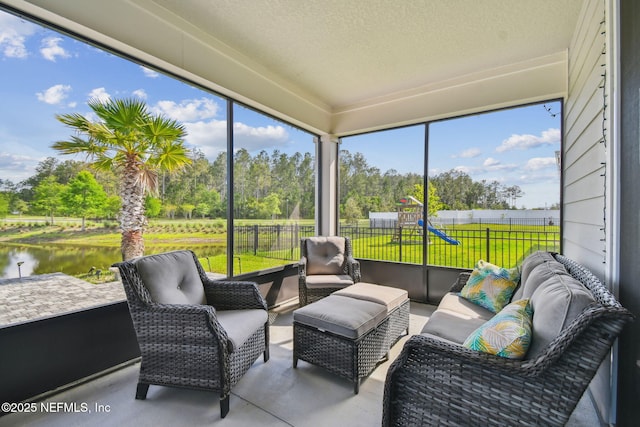 sunroom / solarium featuring outdoor lounge area, a water view, and view of scattered trees