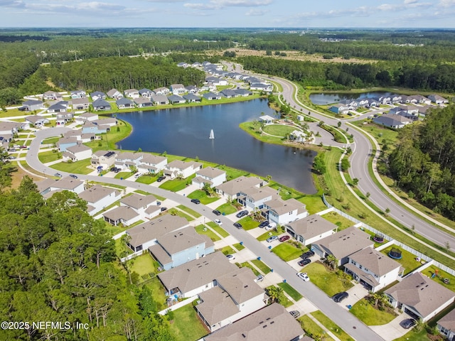 aerial view of property's location featuring a nearby body of water, a heavily wooded area, and nearby suburban area