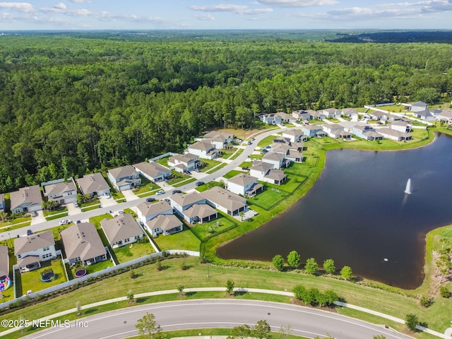 aerial view of property's location with a heavily wooded area, a nearby body of water, and nearby suburban area