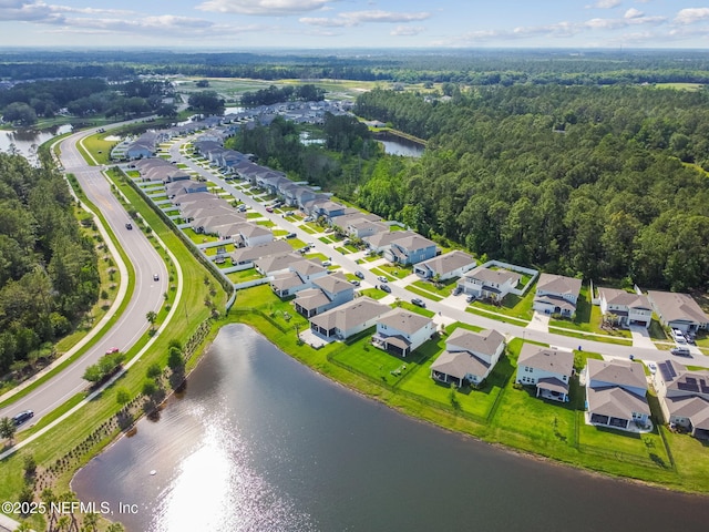 aerial perspective of suburban area with a nearby body of water and a forest