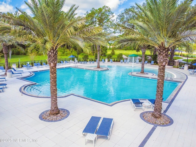 community pool featuring fence and a patio area