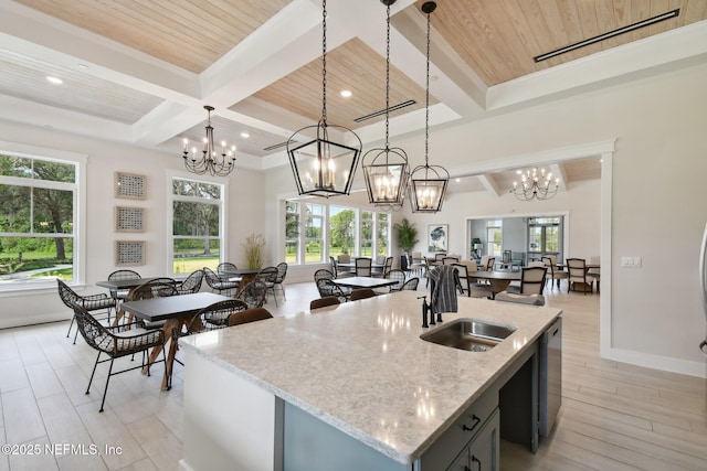 kitchen with a sink, a chandelier, beamed ceiling, wooden ceiling, and hanging light fixtures