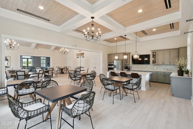 dining area featuring a chandelier, beam ceiling, light wood-style floors, coffered ceiling, and recessed lighting