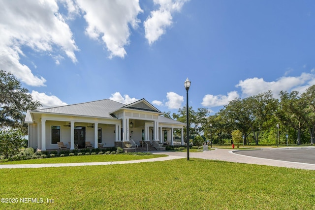 greek revival house featuring a porch, a front lawn, and metal roof