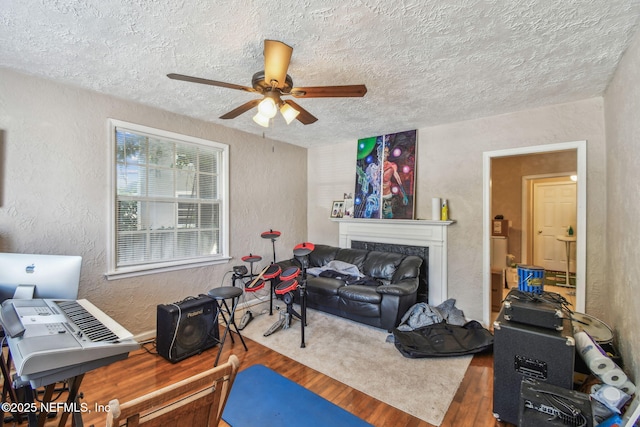 2660 Gale Ct, Jacksonville, FL 32204 - exercise area with a textured wall, wood finished floors, a ceiling fan, a textured ceiling, and a fireplace
