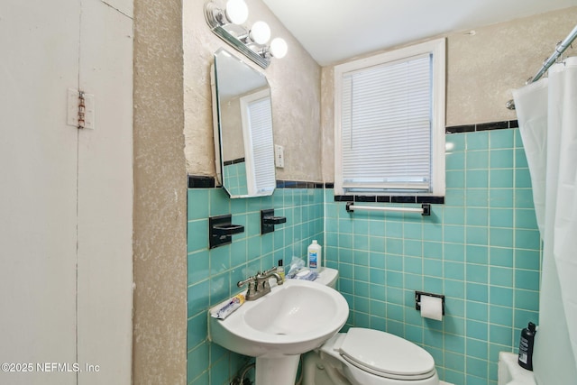 2660 Gale Ct, Jacksonville, FL 32204 - bathroom featuring a sink, a shower with curtain, toilet, tile walls, and a wainscoted wall
