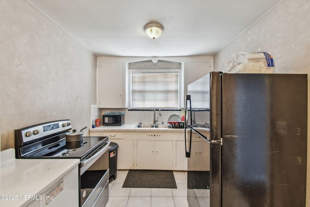 2660 Gale Ct, Jacksonville, FL 32204 - kitchen with black appliances, a sink, light tile patterned flooring, tile counters, and decorative backsplash
