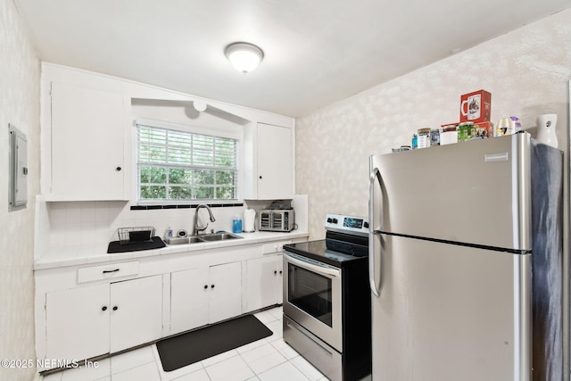 2660 Gale Ct, Jacksonville, FL 32204 - kitchen featuring stainless steel appliances, a sink, white cabinets, tasteful backsplash, and light tile patterned floors