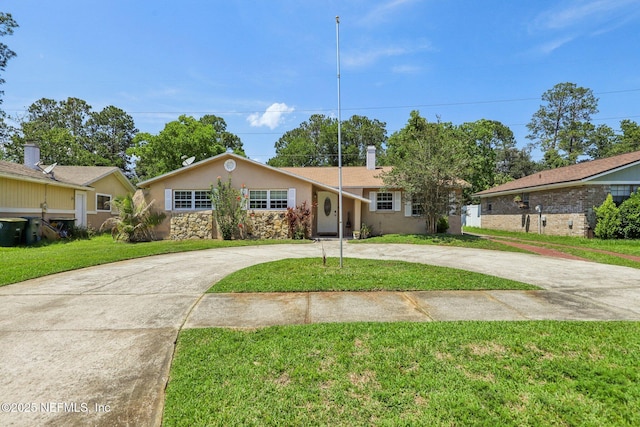 4033 Lazy Hollow Ln N, Jacksonville, FL 32257 - ranch-style home with curved driveway, stucco siding, a front yard, and stone siding
