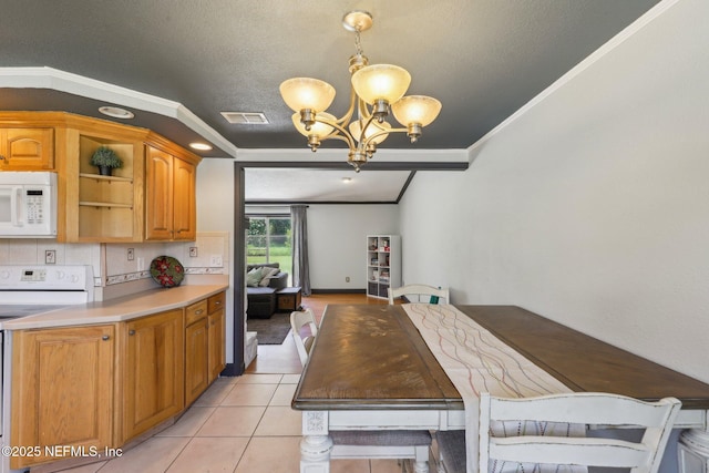 4033 Lazy Hollow Ln N, Jacksonville, FL 32257 - dining space with a chandelier, ornamental molding, a textured ceiling, and light tile patterned floors