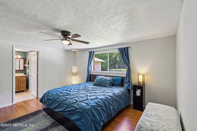 4033 Lazy Hollow Ln N, Jacksonville, FL 32257 - bedroom featuring wood finished floors, a textured ceiling, connected bathroom, and a ceiling fan