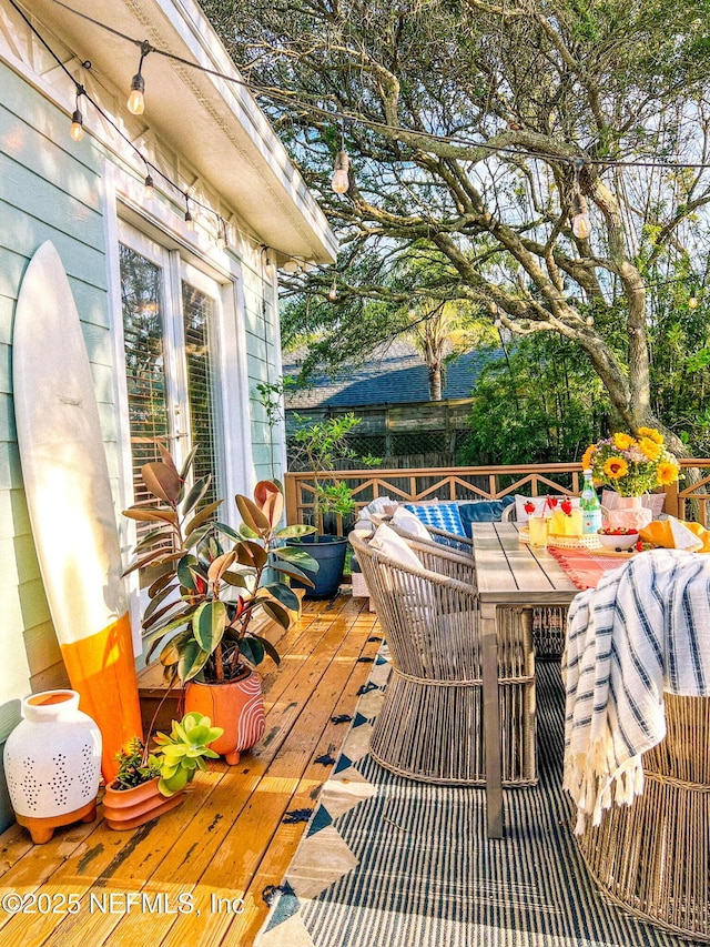 wooden deck with outdoor dining area and french doors