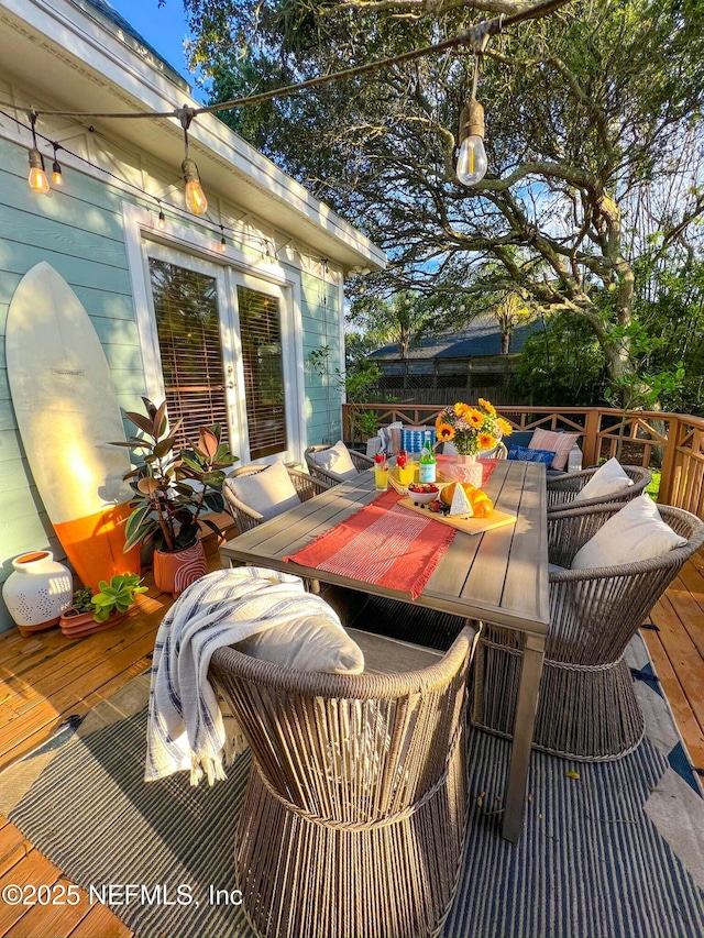wooden deck featuring outdoor dining space and french doors