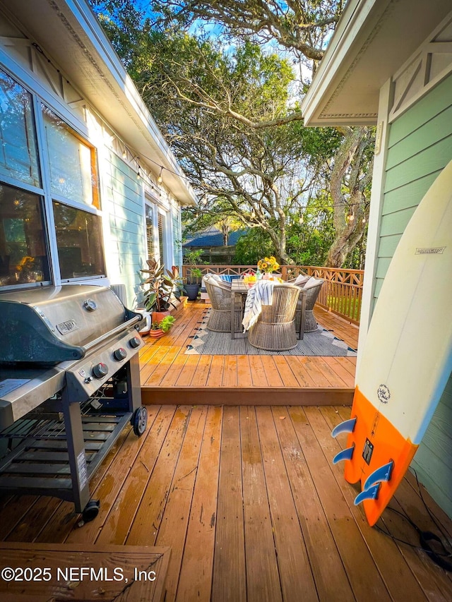 deck with outdoor dining area and grilling area