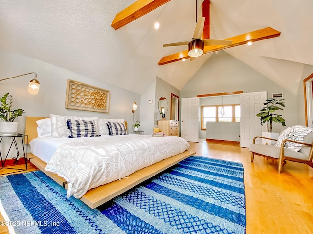 bedroom featuring high vaulted ceiling, wood finished floors, baseboards, ceiling fan, and beam ceiling