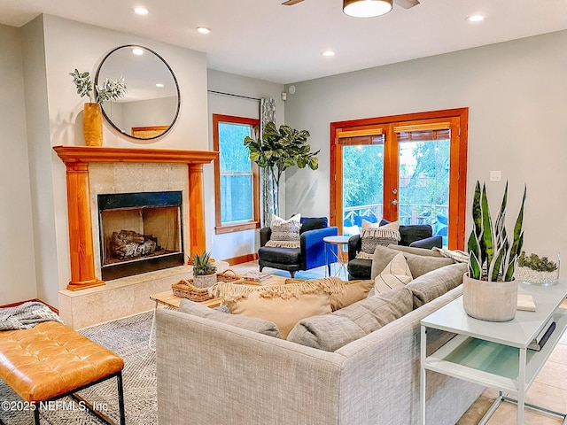 living room featuring french doors, recessed lighting, plenty of natural light, a fireplace, and a ceiling fan