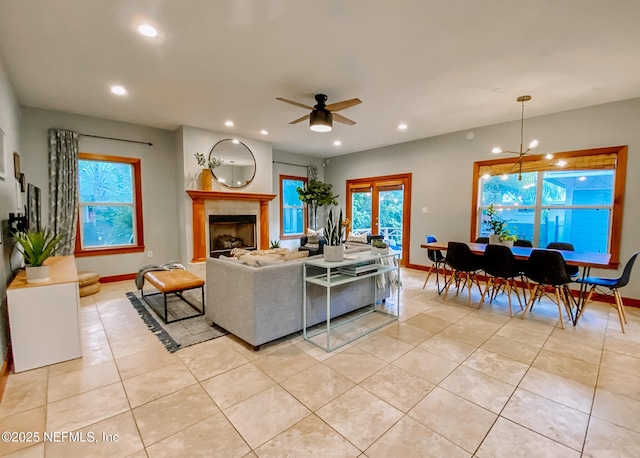 living room with light tile patterned flooring, recessed lighting, ceiling fan, baseboards, and a fireplace