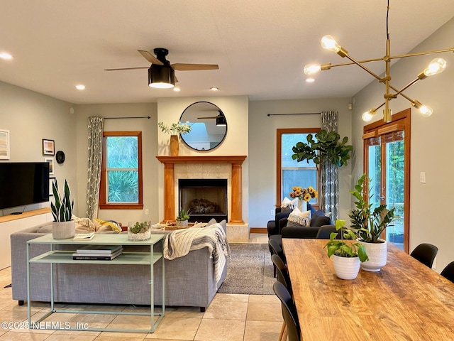 living room with recessed lighting, light tile patterned flooring, a ceiling fan, and a fireplace with raised hearth
