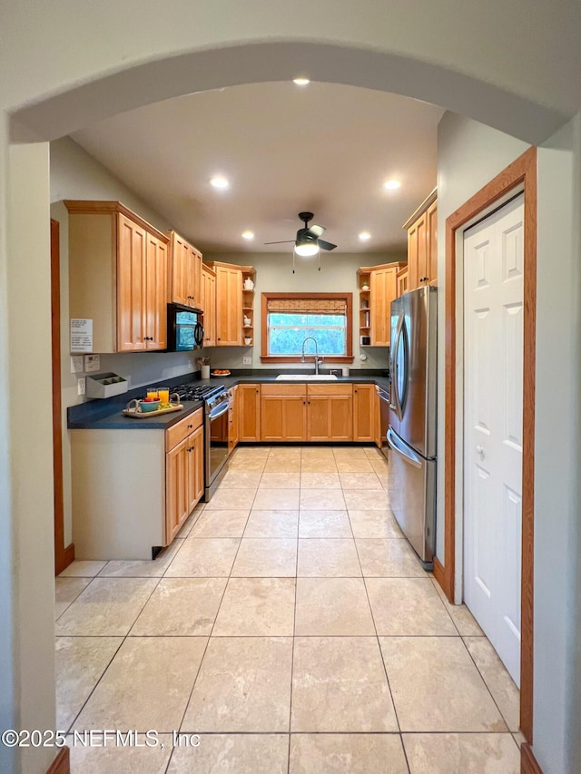 kitchen with appliances with stainless steel finishes, open shelves, a sink, dark countertops, and light tile patterned floors