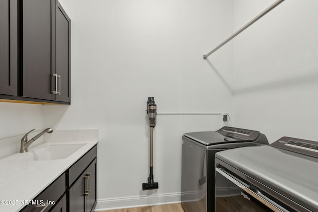 355 Caiden Dr, Ponte Vedra, FL 32081 - laundry area featuring separate washer and dryer, cabinet space, light wood-style floors, and baseboards