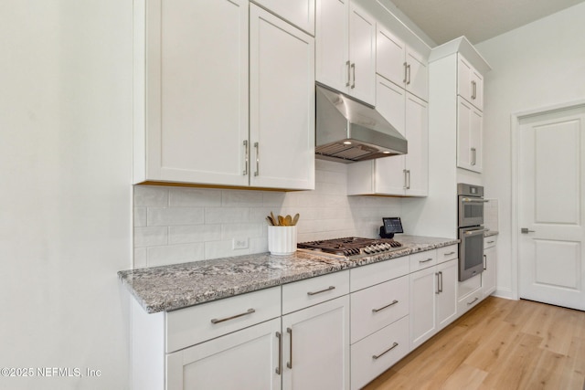 355 Caiden Dr, Ponte Vedra, FL 32081 - kitchen featuring under cabinet range hood, appliances with stainless steel finishes, decorative backsplash, light wood-style flooring, and white cabinetry