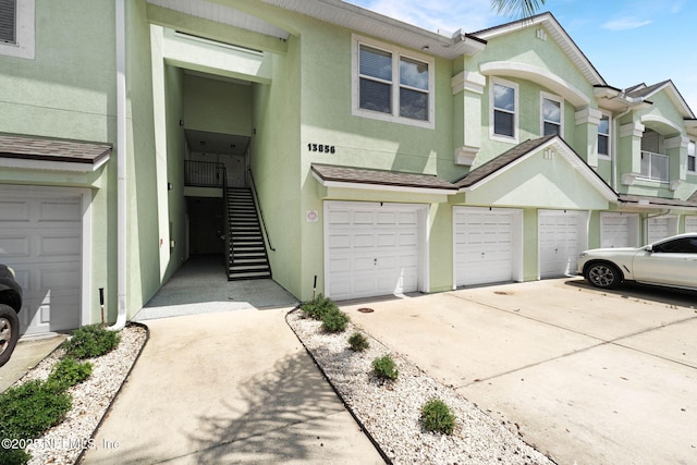 13856 Herons Landing Way Unit 11-7, Jacksonville, FL 32224 - view of property featuring a garage, stucco siding, concrete driveway, and stairs