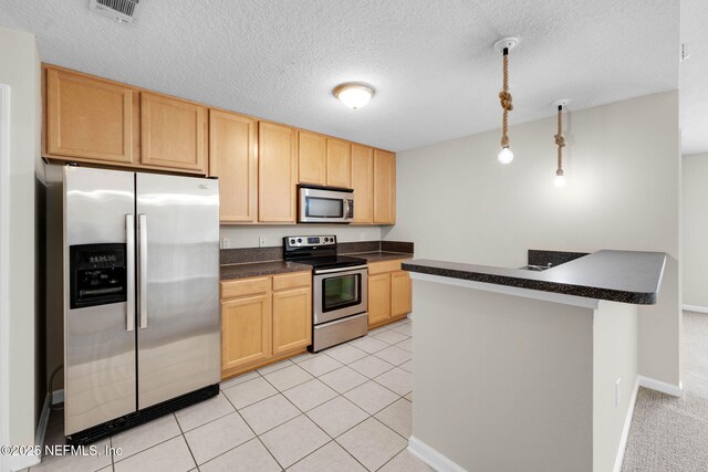 13856 Herons Landing Way Unit 11-7, Jacksonville, FL 32224 - kitchen featuring appliances with stainless steel finishes, light brown cabinets, dark countertops, a textured ceiling, and baseboards