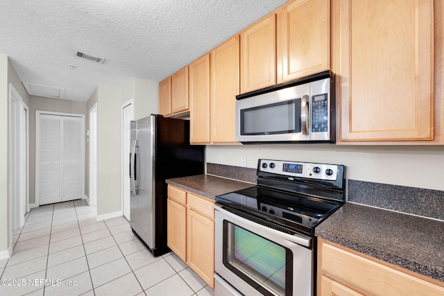13856 Herons Landing Way Unit 11-7, Jacksonville, FL 32224 - kitchen with appliances with stainless steel finishes, light brown cabinets, dark countertops, light tile patterned floors, and a textured ceiling