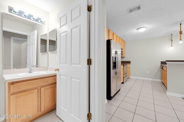 13856 Herons Landing Way Unit 11-7, Jacksonville, FL 32224 - bathroom with vanity, tile patterned floors, a textured ceiling, and baseboards