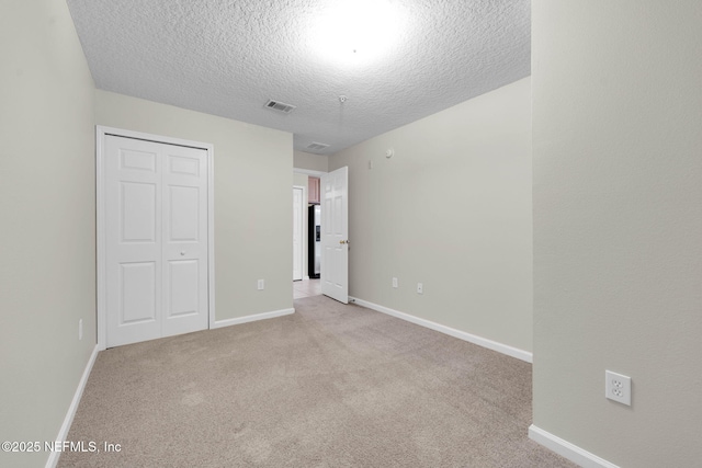 13856 Herons Landing Way Unit 11-7, Jacksonville, FL 32224 - unfurnished bedroom with a textured ceiling, light colored carpet, a closet, and baseboards